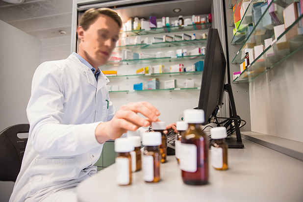 36403998 - pharmacist using computer at desk at the hospital pharmacy